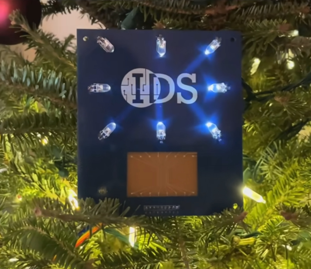 Screenshot of a video of IDS circuit board with printed silver traces and active LED pattern