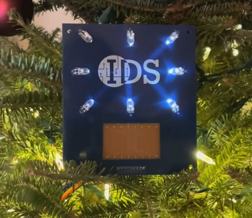 Screenshot of a video of IDS circuit board with printed silver traces and active LED pattern